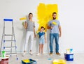 Repair in apartment. Happy family mother, father and child daughter  paints wall Royalty Free Stock Photo