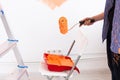 Repair in the apartment. Close-up middle-aged woman paints the wall with paint. Royalty Free Stock Photo