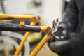 Repair of a bicycle: person disassembling an orange bike in his workshop