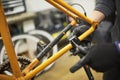 Repair of a bicycle: person disassembling an orange bike in his workshop