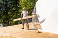 repair, building and home concept - male carrying wooden boards on shoulder.