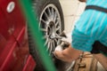 Repair or changing tire car vehicle mechanic screwing car wheel at repair service station Royalty Free Stock Photo