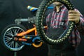 Repair of children\'s bicycles. A mechanic in the workshop holds in his hand an old worn-out tire Royalty Free Stock Photo