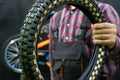 Repair of children's bicycles. A mechanic in the workshop holds in his hand an old worn-out tire Royalty Free Stock Photo