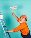 Repair concept. senior man painter use roller on ladder. painting the wall in blue. professional painter in working Royalty Free Stock Photo