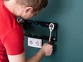 Repair and decoration. `husband for an hour` service. a man attaches a TV mount to a wall.