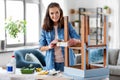 woman sticking masking tape to table for repaint