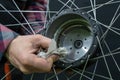 Repair of electric bicycles. A bicycle mechanic holds a wheel with an electric motor and a wrench in his hands. Bicycle wheel