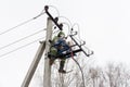 Repair of electrical networks. Power electrician lineman at work on pole. Electrician are climbing on electric poles to install Royalty Free Stock Photo