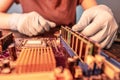 A repair engineer holds a RAM chip with his hands, inserts the RAM into the socket of the computer`s motherboard Royalty Free Stock Photo