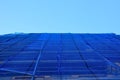 Repair of the facade of the house. The scaffolding is covered with a blue transparent net made of plastic fabric. protects settler