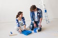 Repair, family, people concept - young couple is going to painting the walls, choosing the color Royalty Free Stock Photo