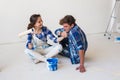 Repair, family and renovation concept - young couple is going to painting the walls, choosing the color Royalty Free Stock Photo