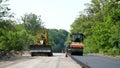 repair of a highway, roller compactor machine and asphalt finisher laying a new fresh asphalt pavement, covering on one Royalty Free Stock Photo