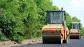 repair of a highway, roller compactor machine , asphalt finisher laying a new fresh asphalt pavement, covering on one Royalty Free Stock Photo
