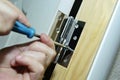 Worker installs door hinges with a screwdriver Royalty Free Stock Photo