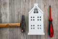 Repair of the house concept. hammer, screwdriver and miniature house on wooden background. Building tools repair house.