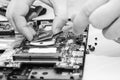 Repair laptops, close-up of hands and dismantled old computer. Ãâlack and white photography