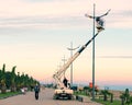 Repair and maintenance of street lamps in city park street at sunset in evening - crane lifted electrician to replace light bulb