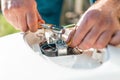 Repair and maintenance of the water heater. The man fixing detail of the boiler. Hands and fingers close up Royalty Free Stock Photo