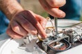 Repair and maintenance of the water heater. A man twists a screwdriver element of the water heater. Close up Royalty Free Stock Photo