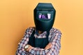 Repair man wearing professional welding mask over head covering face for protection