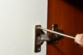 Repair of an old furniture hinge with a screwdriver.