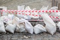 Repair pit on the hole road of sett stone pavers fenced with striped red an white tape. Royalty Free Stock Photo