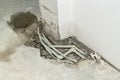 Repair of plastic polypropylene gray sewer pipes in hole in cement floor in apartment. Concept of pipe replacement, water leakage