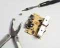 repair of the power supply circuit with powerful transistors and com port. next to it lies a multitool and a screwdriver Royalty Free Stock Photo