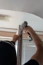 Repair of PVC windows. A worker installs a new pvc window mechanism using a drill. Selective focus, shallow depth of field Royalty Free Stock Photo