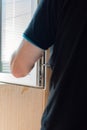 Repair of PVC windows. A worker installs a new pvc window mechanism using a drill. Selective focus, shallow depth of field Royalty Free Stock Photo