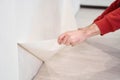 Repair and renovate the interior of the house with their own hands. Close-up of the moment of tearing the old wallpaper off the Royalty Free Stock Photo