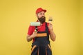 Repair and renovation. Builder regular worker hold paint roller and brush. Perfect surface painting. Apply vinyl paint Royalty Free Stock Photo