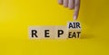 Repair and Repeat symbol. Businessman hand points at turned wooden cubes with words Repeat and Repair. Beautiful yellow background