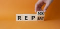 Repair and Repeat symbol. Hand turns cubes and changes the word Repeat to Repair. Beautiful orange background. Businessman hand.