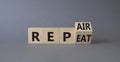 Repair and Repeat symbol. Turned wooden cubes with words Repeat and Repair. Beautiful grey background. Business and Repair and