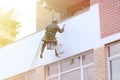 Repair and restoration of a facade of a building. painting color on building wall. facade builder worker with brush, working on hi