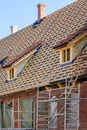 Repair of the roof structures of a historic wooden house and replacement of clay tiles