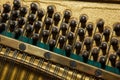 Repair of a stringed musical instrument. Inside view of a piano with brass metal strings and a wooden mallet. A musical