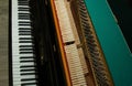 Repair of a stringed musical instrument. Inside view of a piano with brass metal strings and a wooden mallet. A musical