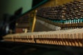 Repair of a stringed musical instrument. Inside view of a piano with brass metal strings and a wooden mallet. A musical