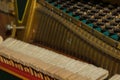 Repair of a stringed musical instrument. The interior of a piano with brass metal strings and a wooden mallet. Old