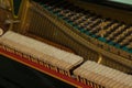 Repair of a stringed musical instrument. The interior of a piano with brass metal strings and a wooden mallet. Old