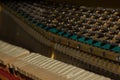 Repair of a stringed musical instrument. The interior of a piano with brass metal strings and a wooden mallet. Old