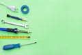 Repair tools on a green background. Measuring tape, screwdriver, soldering iron. Place for text. Copy space. Flat lay