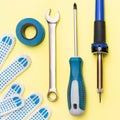 Repair tools on a yellow background. Measuring tape, screwdriver, construction gloves. Flat lay. Top view. Handyman tool