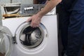 Repair of washing machines, repair of large household appliances. Repairman disassembles a washing machine