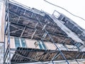 Repair work on the facade of the building with the help of wooden scaffolding, structures, restoration of the old house Royalty Free Stock Photo