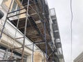 Repair work on the facade of the building with the help of wooden scaffolding, structures, restoration of the old house Royalty Free Stock Photo